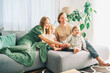 © annanahabed - Happy young family of four relaxing on a couch, couple playing with baby girl and toddler boy