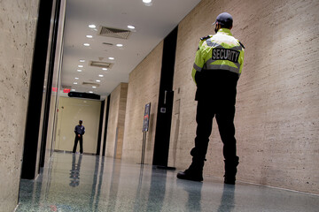 Wall Mural - Low angle shot of security guards patrolling inside commercial b