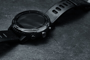 Wall Mural - A modern carbon fiber smartwatch on a black board