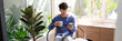 © snowing12 - Handsome Asian teenager man wearing casual clothes in glasses using smart phone browsing Internet on mobile phone device at the living room.