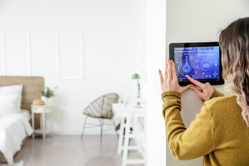 Canvas Print - Woman using smart home security system control panel