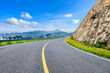 Asphalt highway and mountains with modern city skyline scenery.