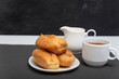 Homemade delicate profiteroles and cup of coffee. Traditional French eclairs. Side view