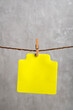Blank yellow paper card hang with clothespin on rope. Copy space. Place for your text.