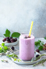 Wall Mural - Natural healthy detox, fruit dessert, healthy dieting concept. Blackberry milk shake or Yogurt smoothie in glass jar on a light stone tabletop. Copy space.