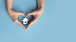 © fidaolga - A paper house in the hands of a man. A symbol of a person's love for their home