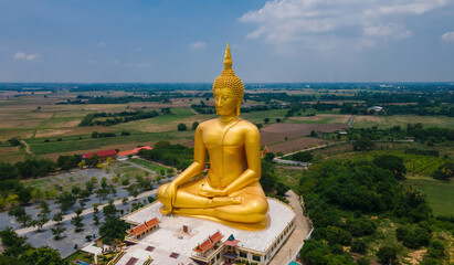 Wall Mural - aerial view of big ancient golden mediated Buddha at Wat Muang Temple, Ang Thong province, Thailand, drone high angle top view