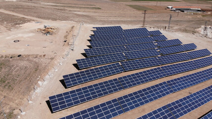 Wall Mural - Aerial view of close up solar power panels, in desert.