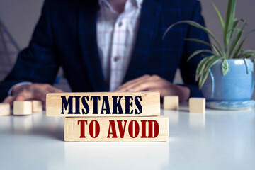 Wall Mural - Mistakes To Avoid text concept written on wooden blocks lying on a table