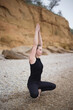 © Aleksandra Iarosh - young beautiful woman doing an asana on the sand by the sea