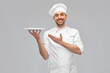 © Syda Productions - cooking, culinary and people concept - happy smiling male chef in toque holding empty plate over grey background
