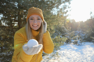 Wall Mural - Woman holding snowball outdoors on winter day, space for text