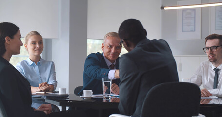 Happy businesspeople shaking hands greeting each other at business meeting in office