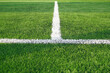 Artificial grass of football field with white stripe, Soccer corner line detail, Green astro turf for texture background, Perspective