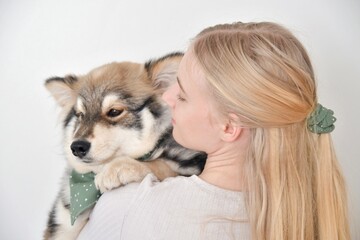 A woman hugging puppy Finnish Lapphund dog