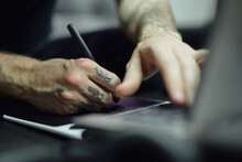 Man Sketching On Computer In Tattoo Salon