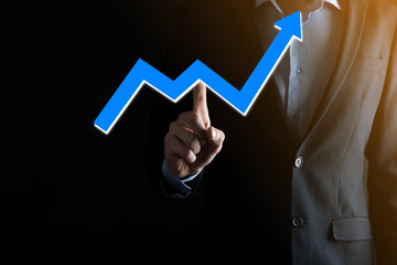 Businessman man holding a graph with positive profits growth. plan graph growth and increase of chart positive indicators in his business.more profitable and growing.