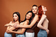 © iordani - young pretty caucasian, afro, asian, scandinavian woman posing cheerful together on brown background, lifestyle diverse nationality people concept