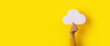 cloud in hand over yellow background, storage concept, panoramic layout