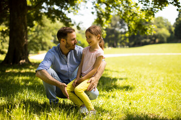 Father with daughter having fun on the grass at the park