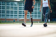 © Drazen - Unrecognizable athlete with leg prosthetic and his female friend walking at sports field while coming to practice.