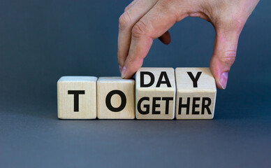 Today we are together symbol. Businessman turns wooden cubes and changes the word together to today. Beautiful grey background, copy space. Business and today we are together concept.