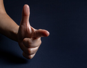 White woman's hand on a dark background making mention of a gun. A sign widely used by the president of Brazil Jair Bolsonaro in campaigns and events in which he participates.