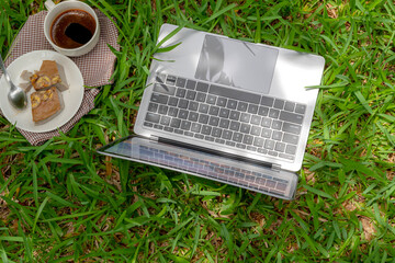 Top view of laptop on green grass field.