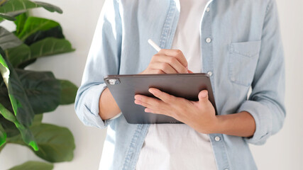 Wall Mural - close up of man hand writing on digital tablet while working at home, online study, telecommunicatio