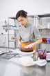 © Anischenko - A bright pastry chef girl is engaged in the preparation of a cake