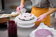 © Anischenko - A bright pastry chef girl is engaged in the preparation of a cake