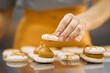 © Anischenko - A bright girl holds fresh cakes and macaroons in her hands