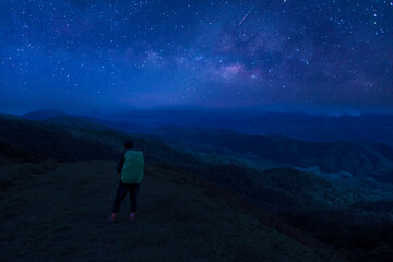 Wall Mural - colorful night sky with stars and silhouette of a standing man on the stone. blue milky way with man