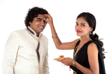 Indian young sister tying rakhi on brother's wrist, a tradition on Raksha Bandhan festival