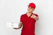 © luismolinero - Pizza delivery man with work uniform picking up pizza boxes isolated on white background pointing front with happy expression
