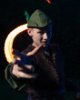 © ISliM - A guy in a Robin Hood costume stands in the background of a burning torch