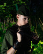 © ISliM - Peter Pan plays a flat sitting in the grass against the backdrop of the forest. Cosplay on Peter Foam. Robin Hood