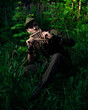 © ISliM - Peter Pan plays a flat sitting in the grass against the backdrop of the forest. Cosplay on Peter Foam. Robin Hood