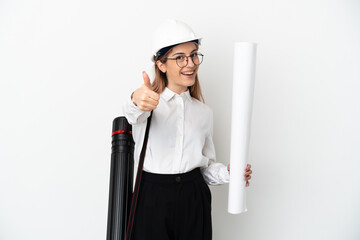 Young architect woman with helmet and holding blueprints isolated on white background with thumbs up because something good has happened