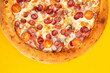 © Игорь Соколов - Pizza with sausages and tomatoes. On a yellow background.