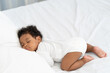 © ronnachaipark - black african american baby sleeping on a white mattress.