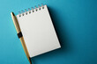 © eskay lim - blank note pad with pen on blue background