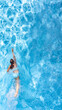 © Iuliia Sokolovska - Active girl in swimming pool aerial drone view from above, young woman swims in blue water, tropical vacation, holiday on resort concept