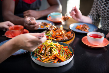 people at the table are eating oriental food