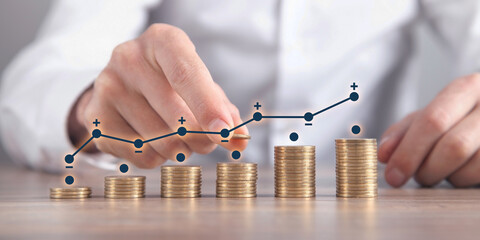 Wall Mural - Man stacking coins with a graph of profit.