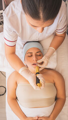 Sticker - Vertical shot of a young Hispanic female getting a filler injection at a spa