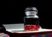 A Glass Jar Filled With Red 4-sided Dice