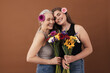 © Artem Varnitsin - Two smiling women of different ages standing head to head in studio. Caucasian females with bouquets in hands and flowers in their hair.