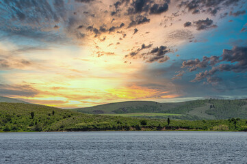 Sticker - Vibrant shot of the orange toned sunset sky seen through wavy mountain lake waters