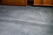 © knelson20 - Old, stained, and wrinkled blue carpet poses a tripping hazard, home interior